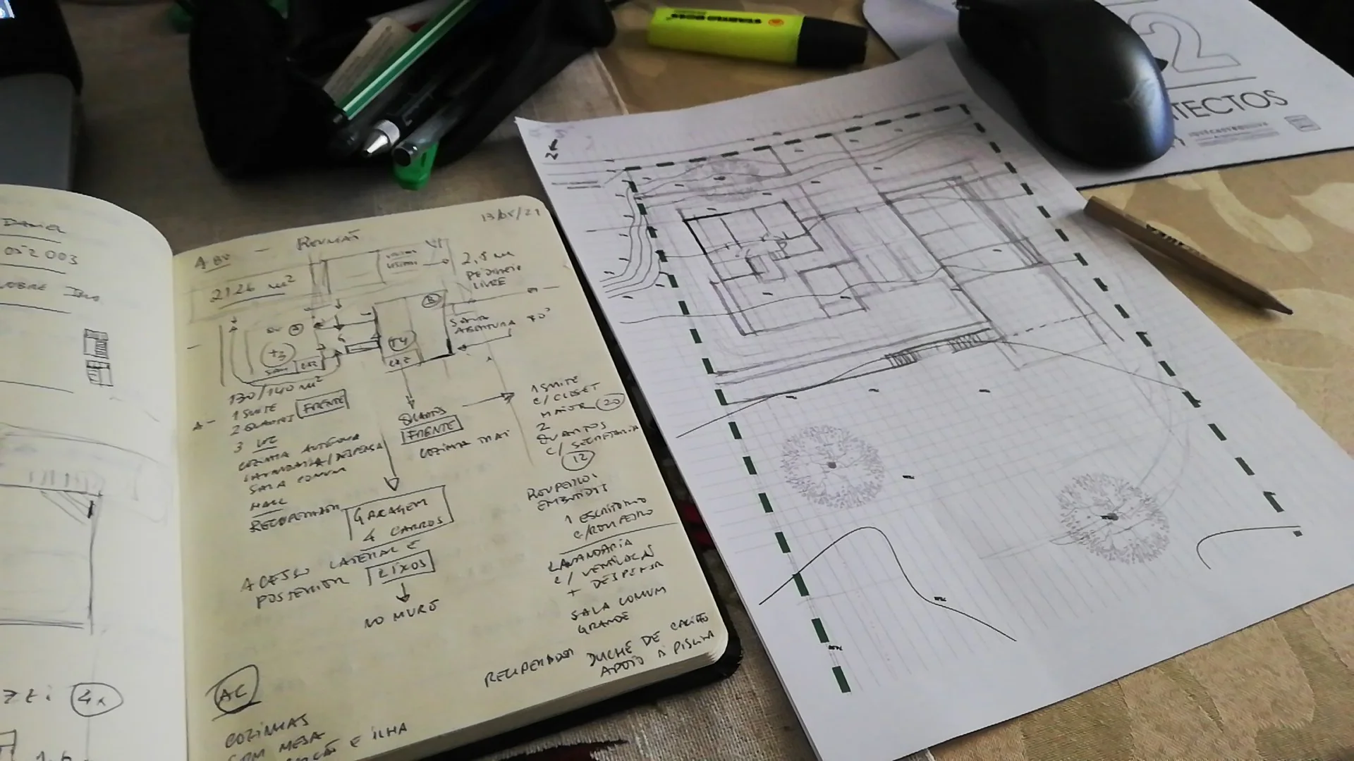 Sketchbook and architectural drawings on a worktable